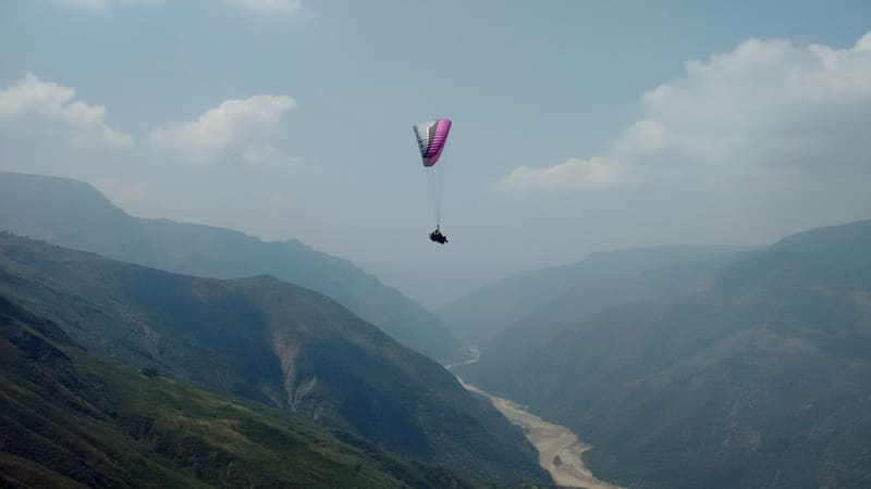 Un parapente vuela sobre las laderas del Cañón del Chicamocha.