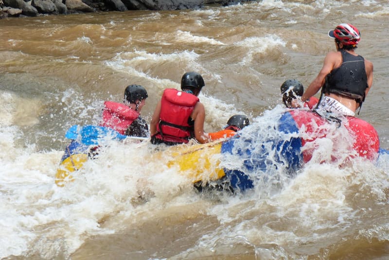Una balsa de rafting con remeros de casco y chaleco salvavidas atraviesa un rápido del río Fonce.